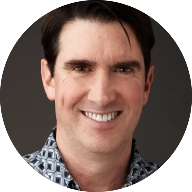 Adam Cheyer smiling in a patterned shirt for STEAM Magic school assemblies